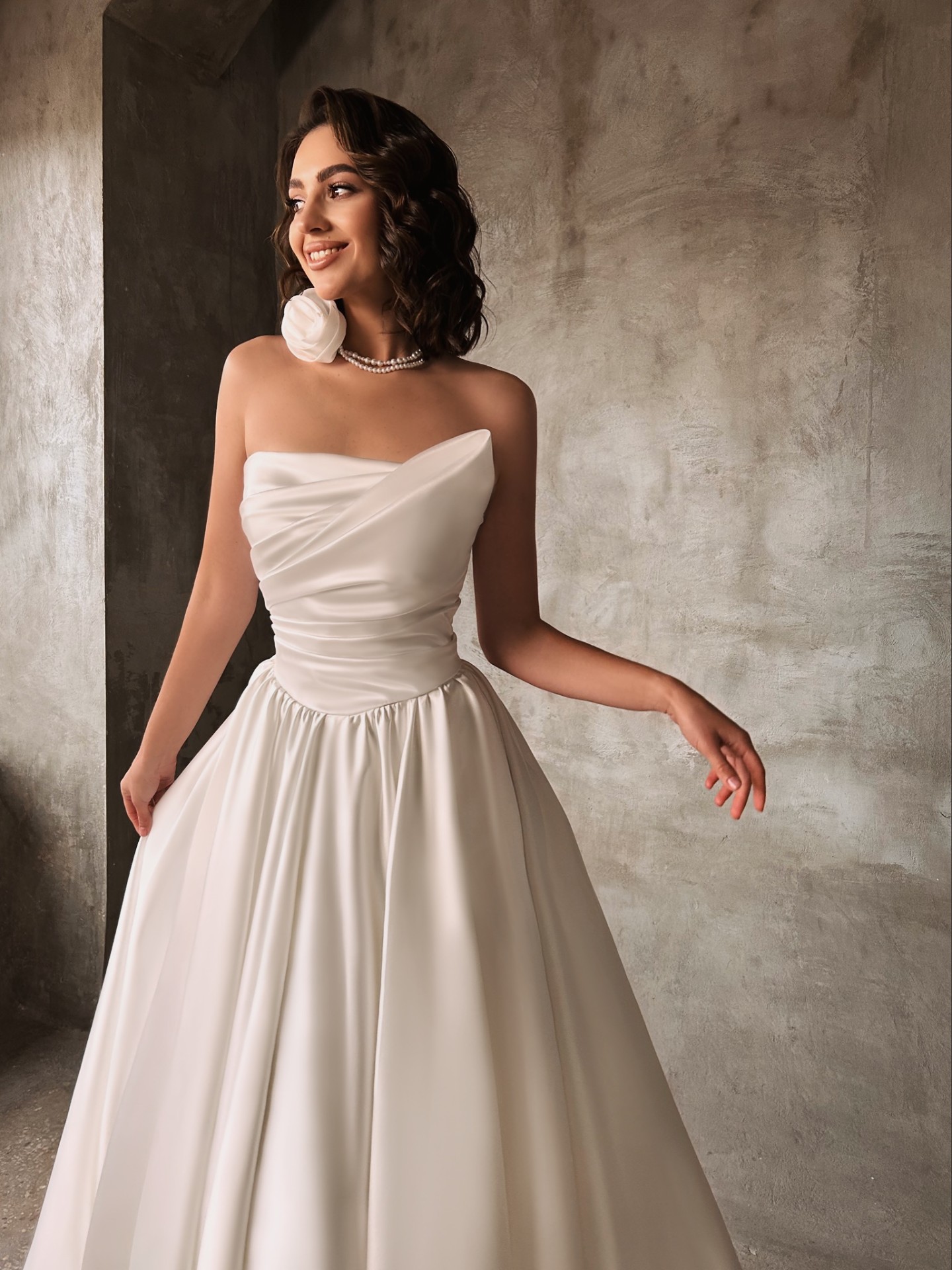 Roberta — close-up of the asymmetric draped satin bodice and pearl rosette necklace styling