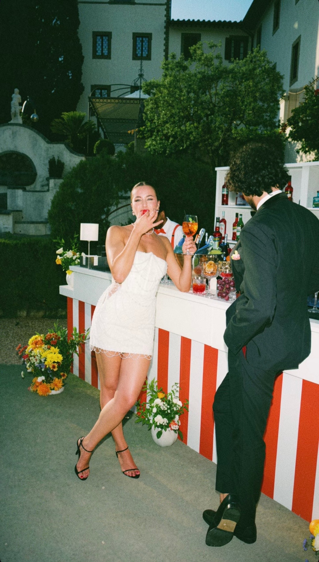 Jenny — playful candid of bride in beaded mini dress at outdoor cocktail bar
