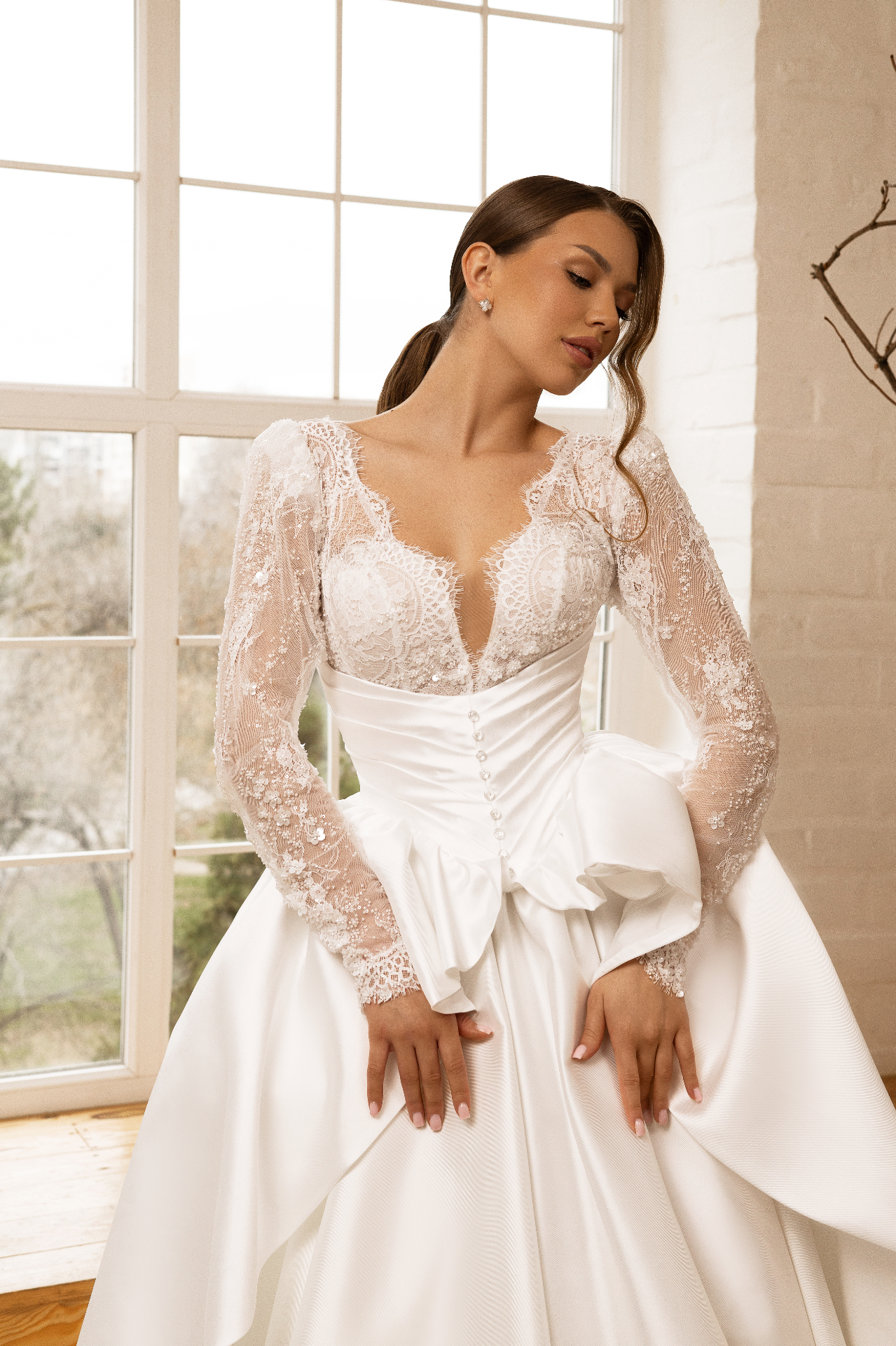 Sandra — close-up of deep V-neckline, illusion sleeves, and ruched satin waist