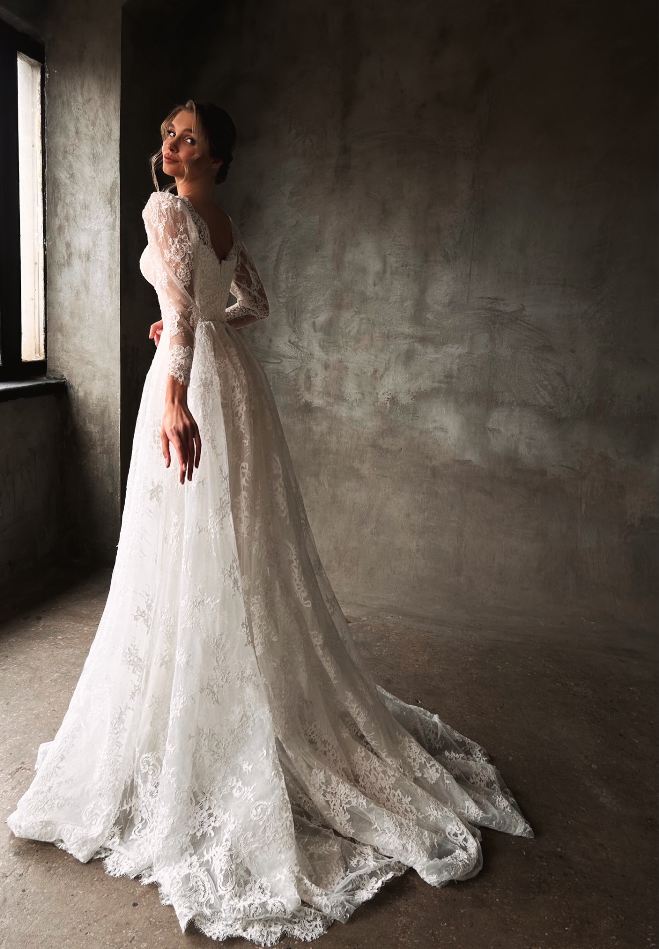 Clio — side view showcasing flowing lace A-line silhouette and elegant train