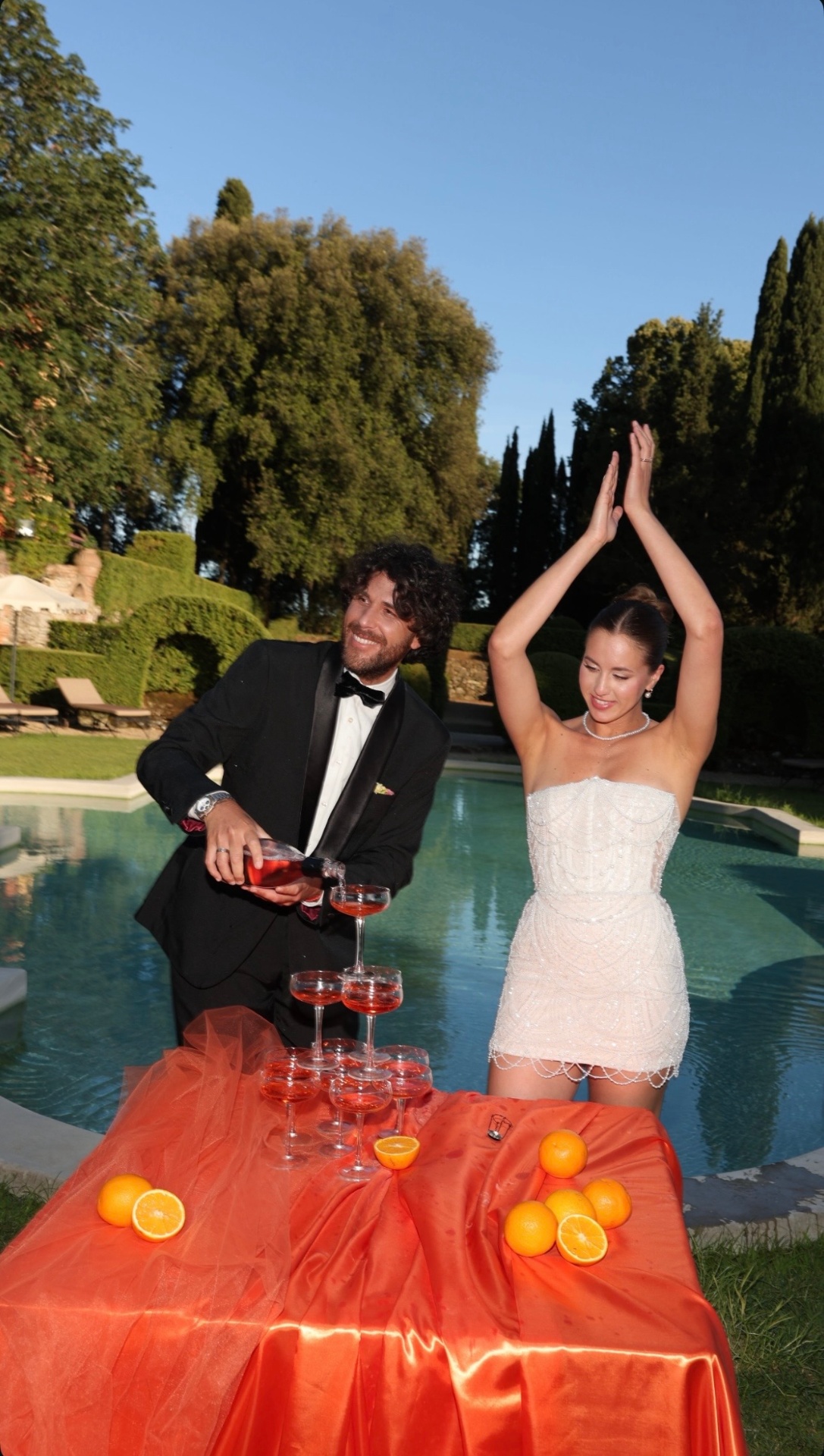 Jenny — bride in beaded mini dress celebrating poolside with champagne tower