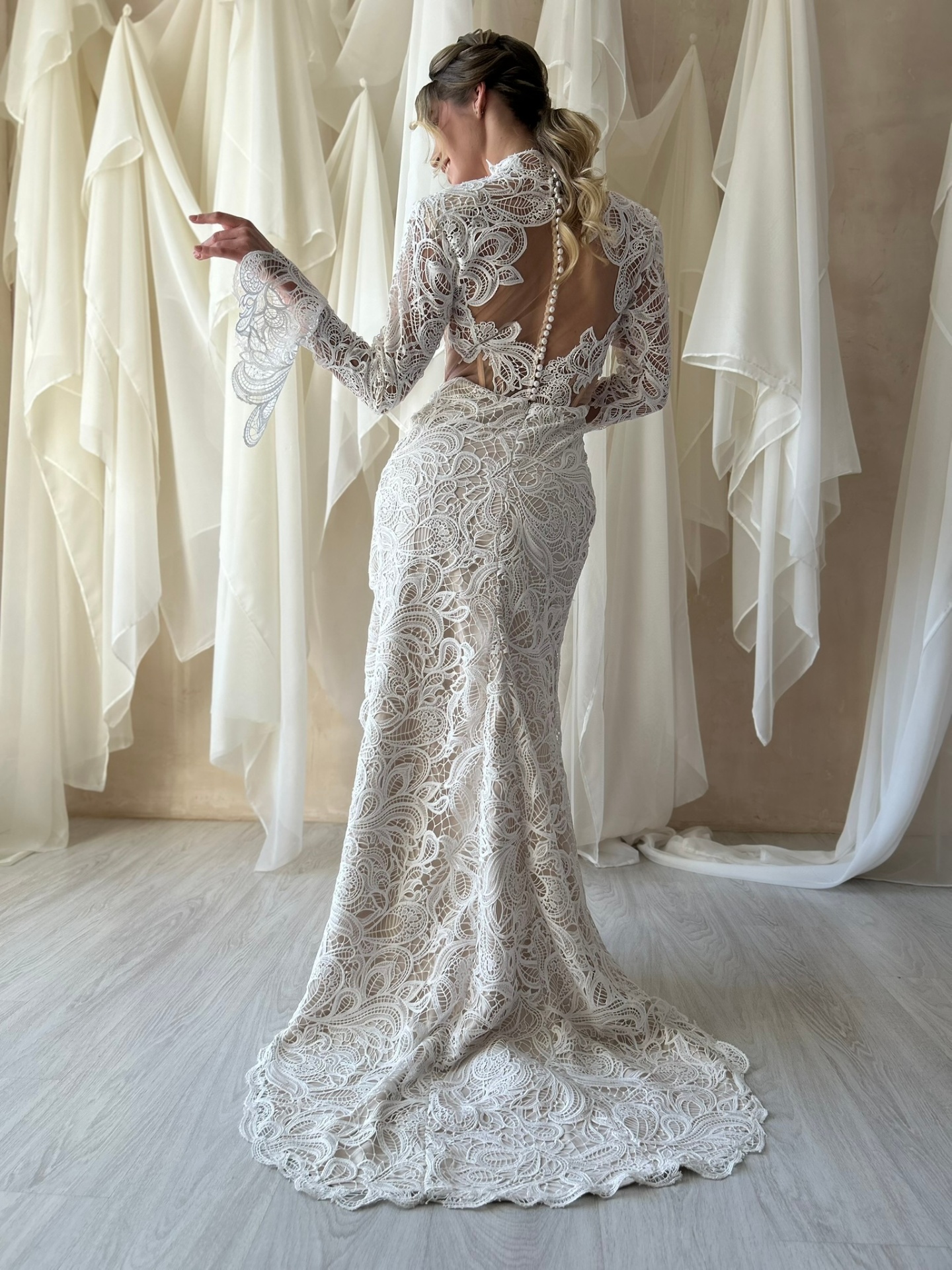 Keira — back view showing open back with pearl button detail and sweeping lace train