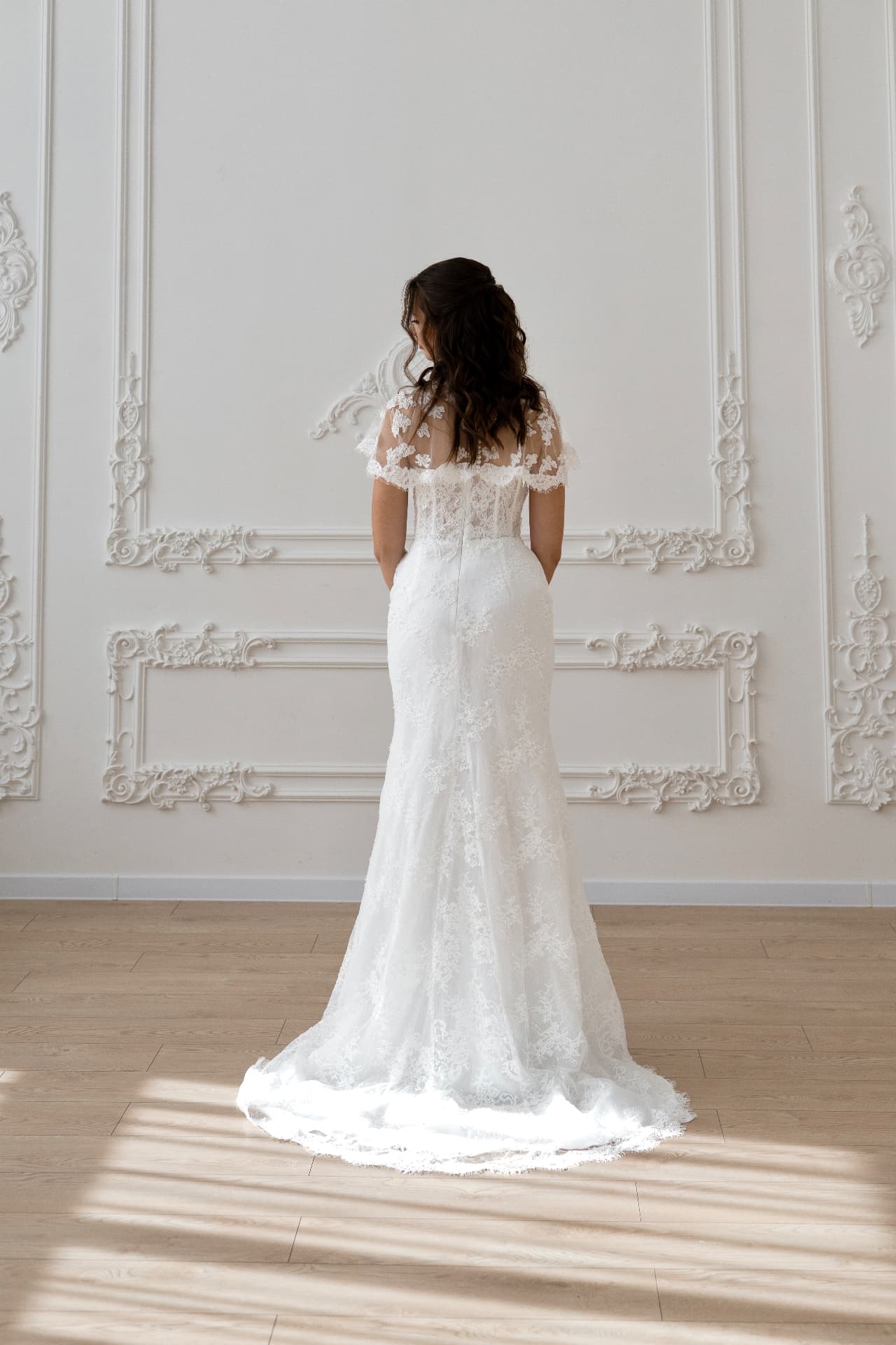 Lachesis — back view with flared skirt and delicate lace train