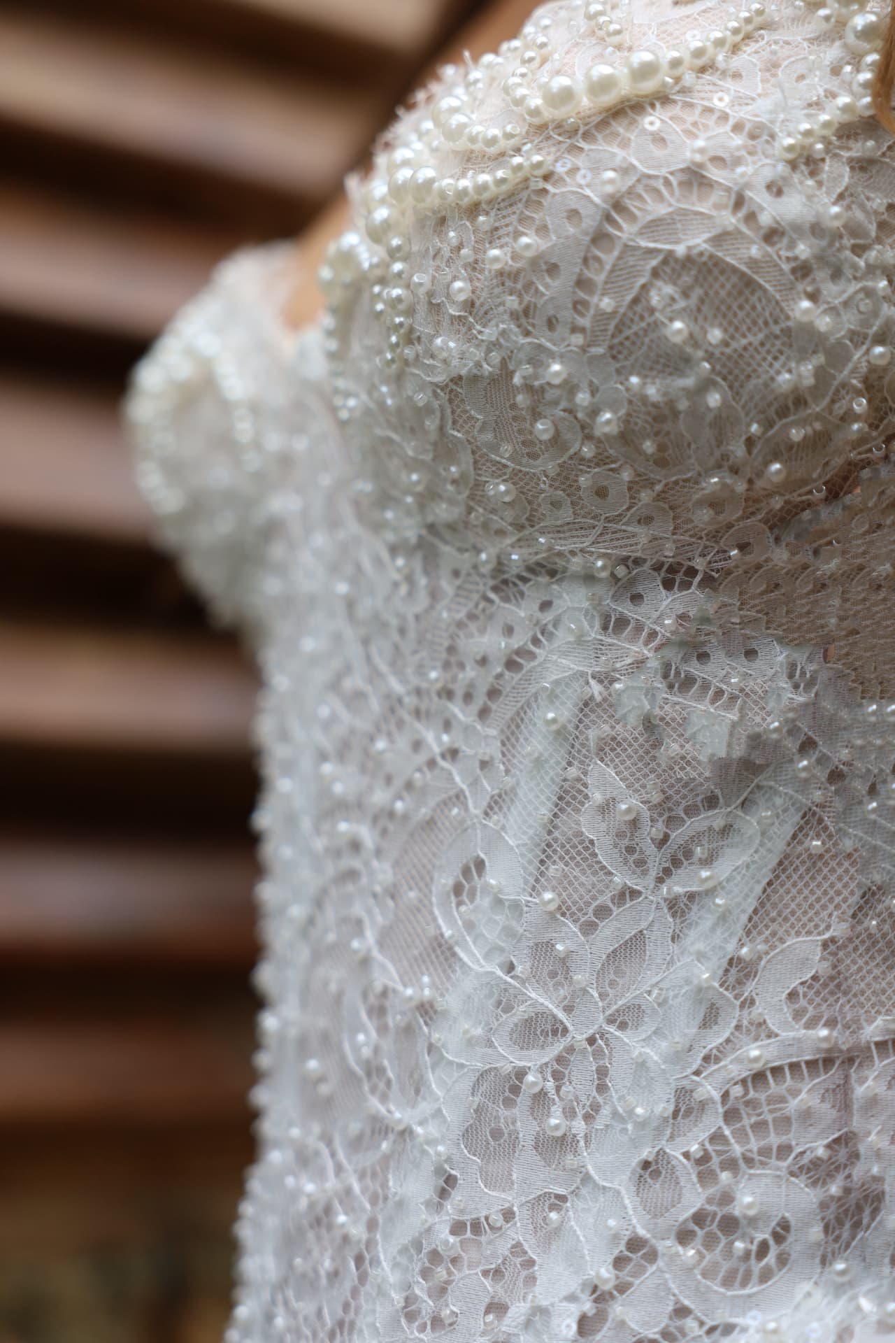 DÉSIR — close-up of the intricate lace and pearl detailing on the corset bodice
