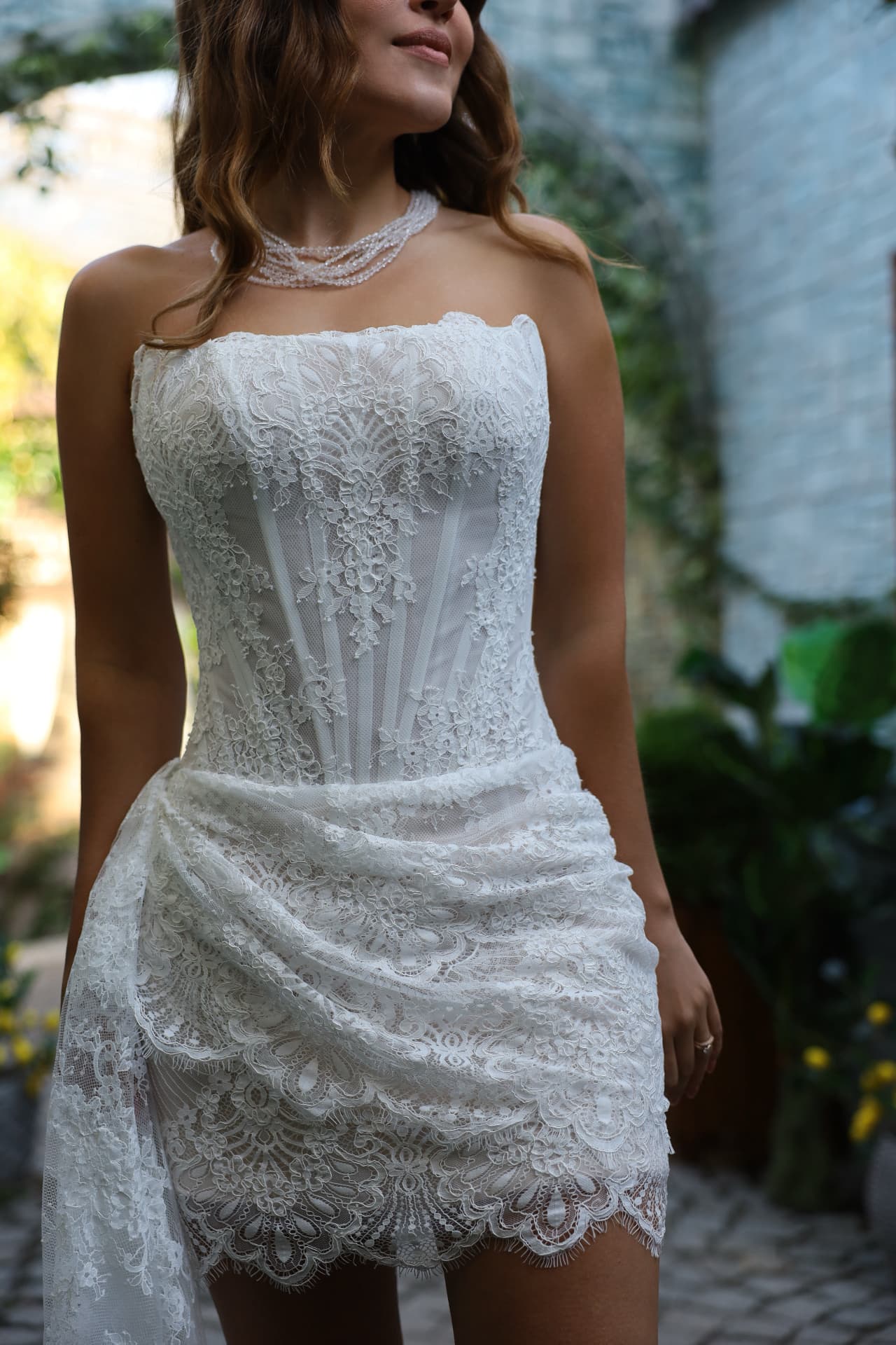 MIDNIGHT — close-up of the fitted lace silhouette and softly draped asymmetric skirt