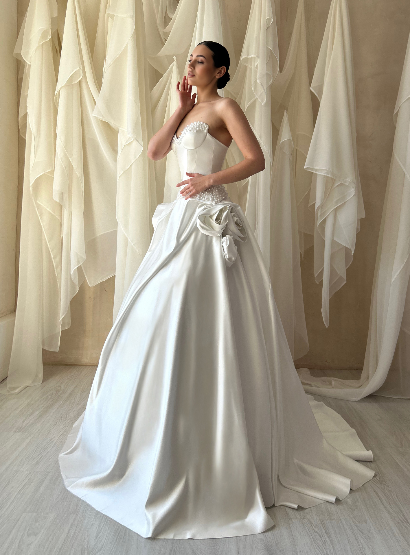 Madeline — side profile of architectural satin ballgown with sculptural floral accents at the waist