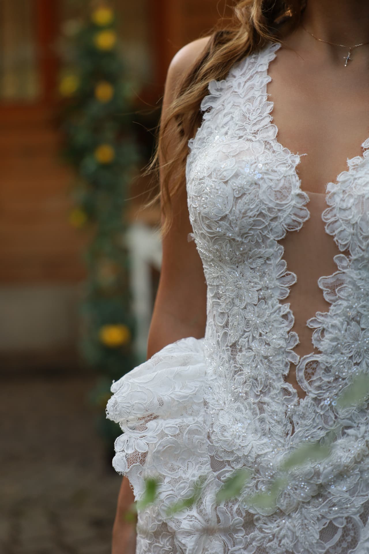FLORENCE — close-up of the plunging V-neckline, floral lace appliqué and sculptural peplum