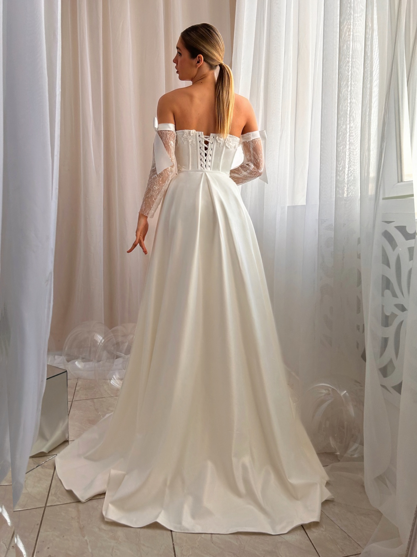 Delilah — back view of strapless corset bodice with flowing satin overskirt and train