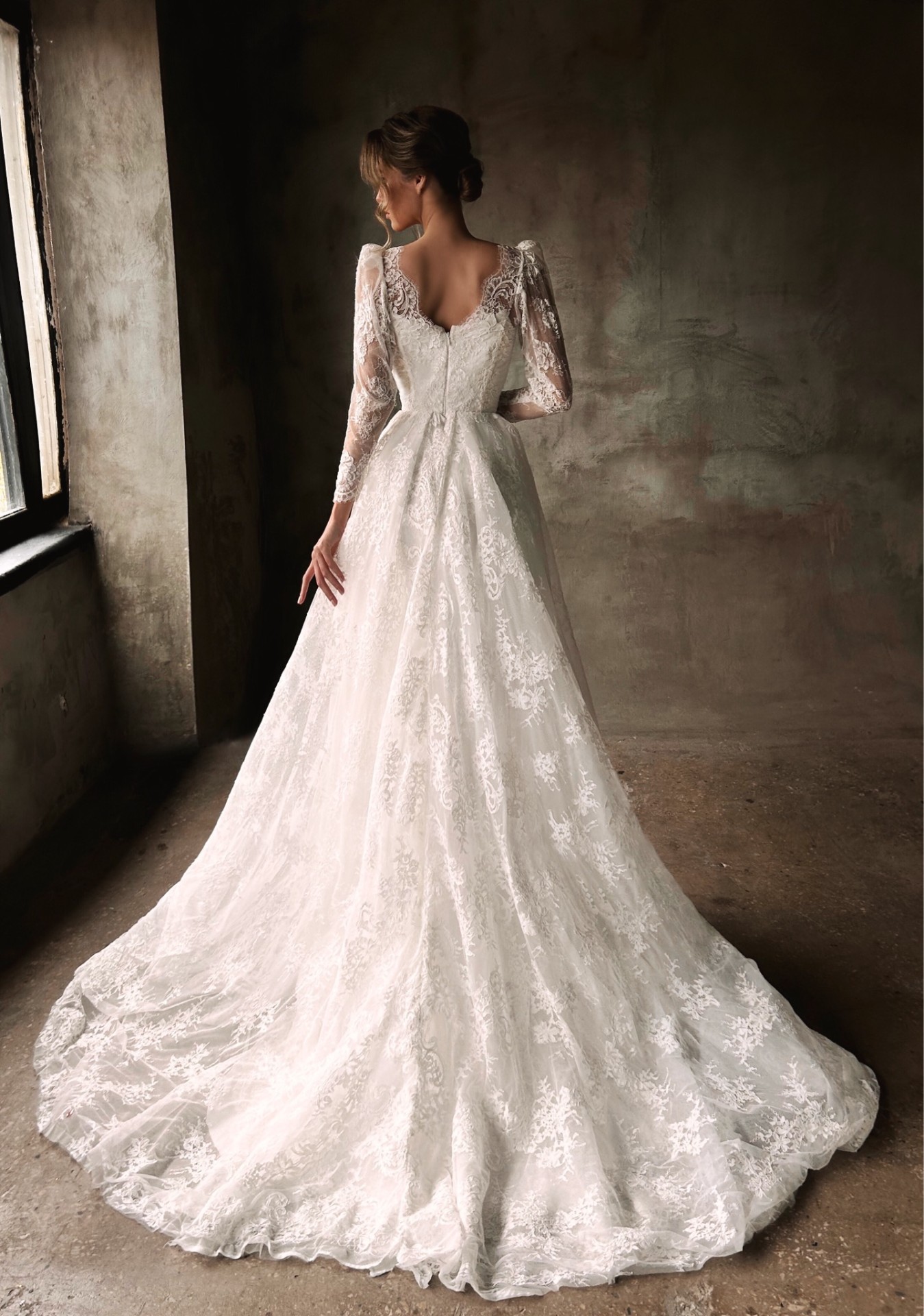 Clio — back view of V-back lace bodice with full multi-layered lace skirt and train