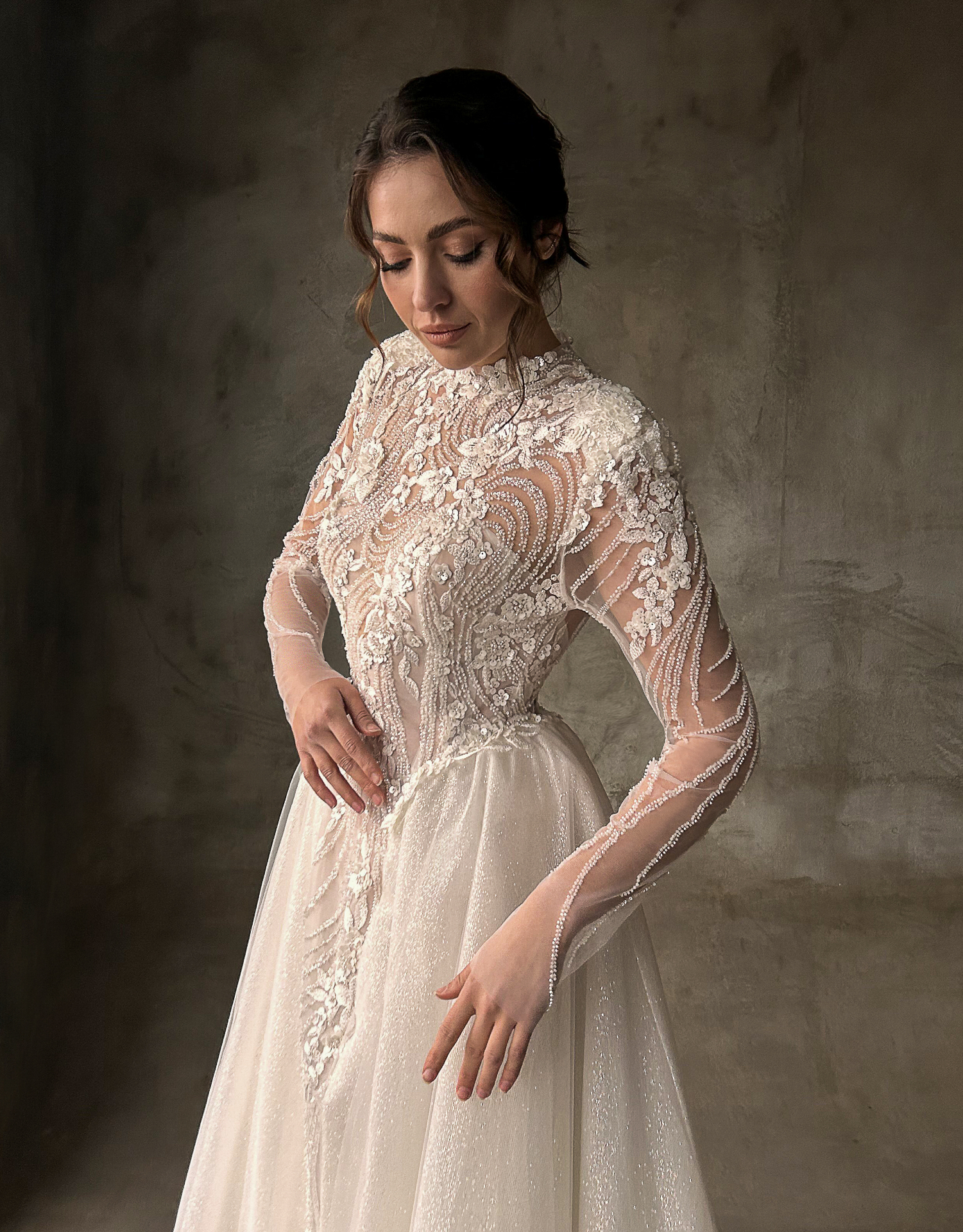Ornella — three-quarter view showcasing the sculpted lace bodice, long sleeves and detachable overskirt volume