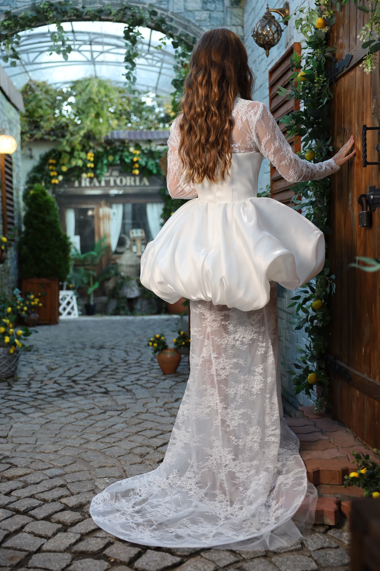 NOIR — back view, long lace skirt with flowing train layered beneath the satin bubble skirt